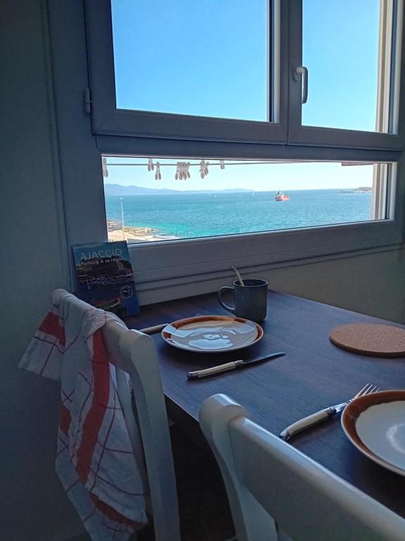 - une table avec vue sur l'océan depuis une fenêtre dans l'établissement Lumineux et cosy F3 vue mer, à Ajaccio
