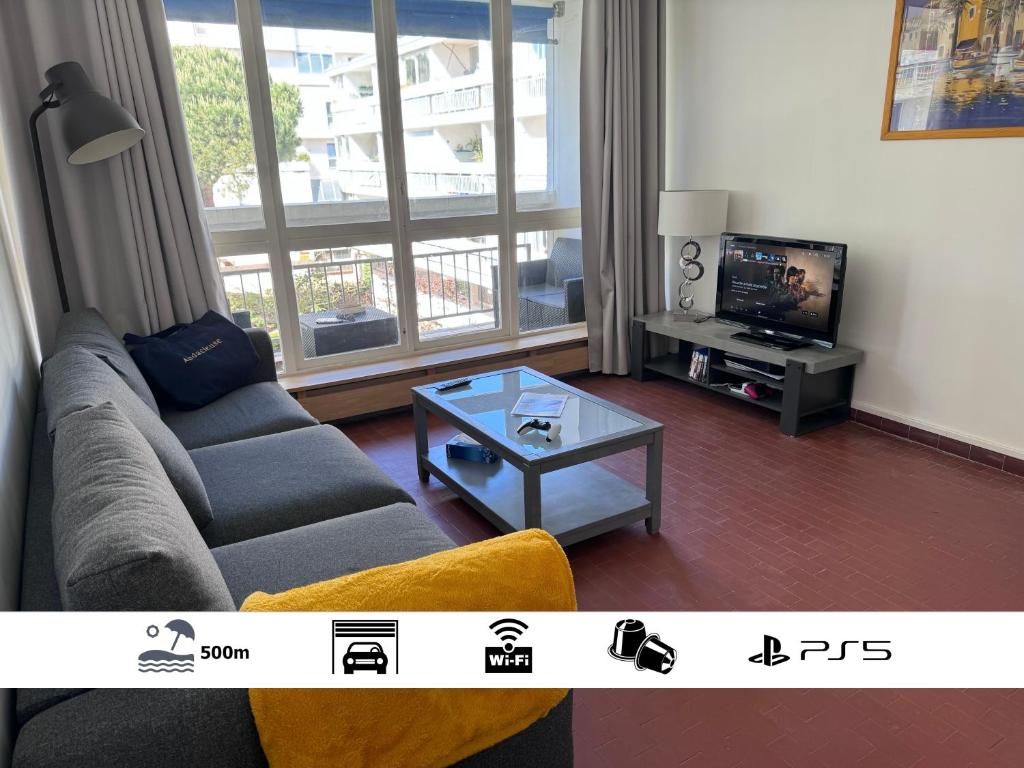 un salon avec un canapé et une télévision dans l'établissement L ECHAPPEE MER Grand 2 pièces centre 500m plage Garage Wifi Fibre PS5 Tout équipé, à La Grande Motte
