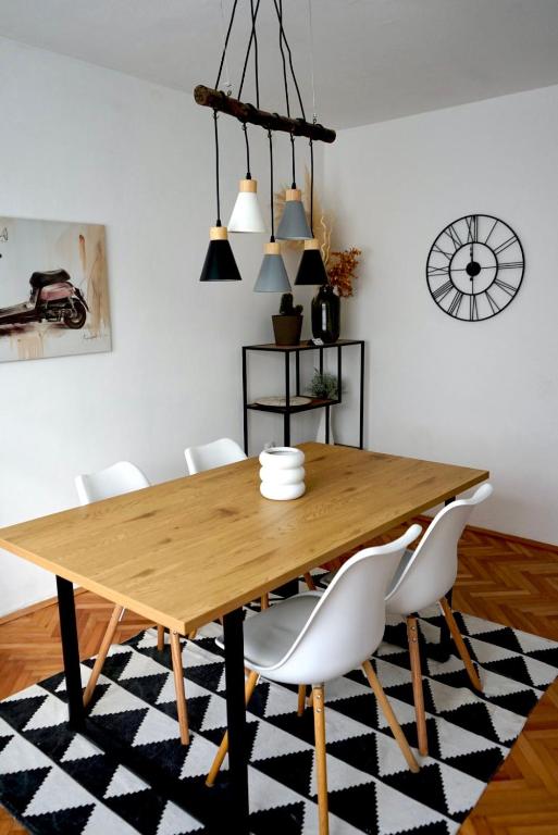 a dining room with a wooden table and white chairs at Barbara in Gospić