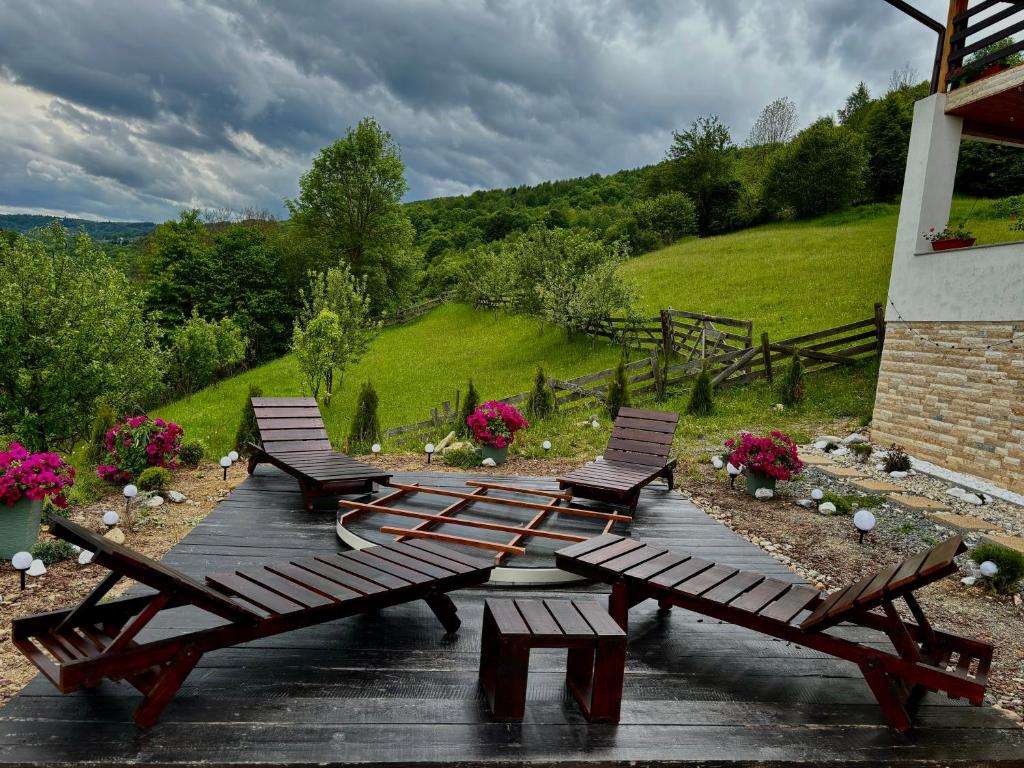 a group of benches sitting on a wooden deck at Cabana FloriDeea in Scrind-Frăsinet