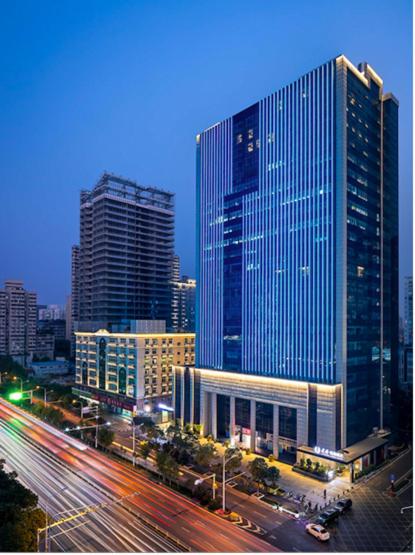 uno skyline cittadino con edifici alti e una strada con auto di Campanile Wuhan Zhongnan Road Metro Station a Wuhan