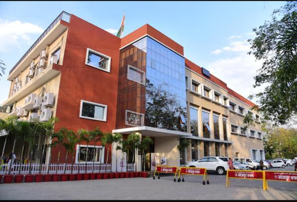 a large red building with cars parked in front of it at Hotel Stay Casa in Bhopal