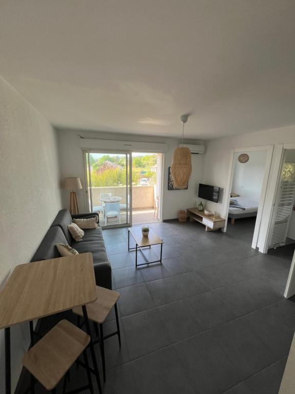 un salon avec un canapé et une table dans l'établissement T2 entre mer et montagne, à Santa-Lucia-di-Moriani