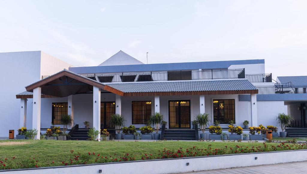 un edificio bianco con portico e prato di The Augusta Club & Resort a Limodra