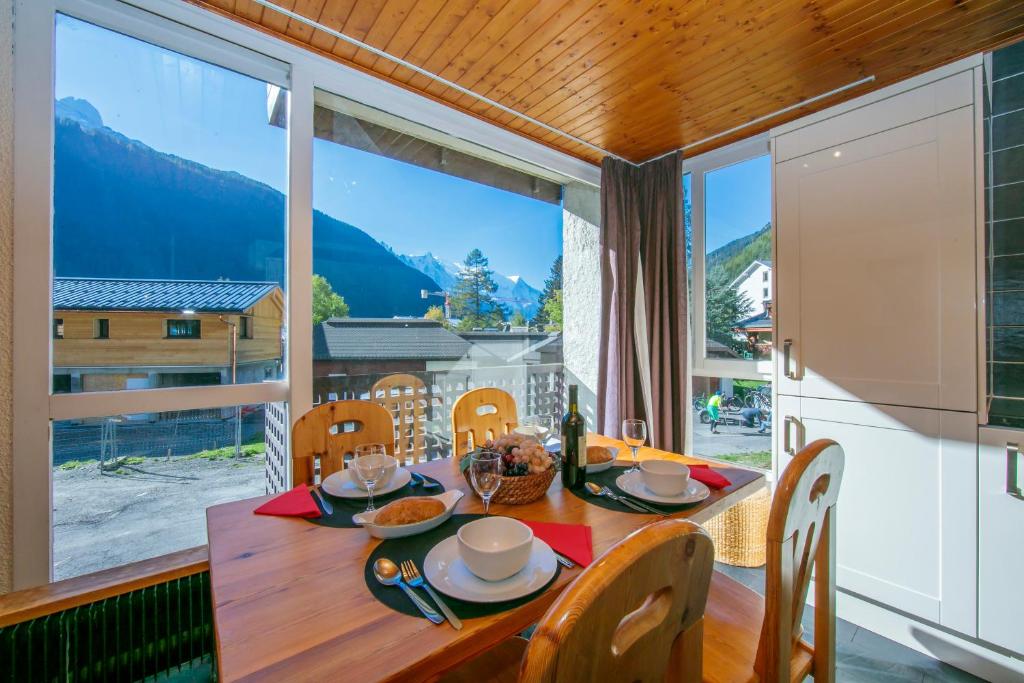 a dining room with a table and a large window at Residence de Lognan- Les Jorasses 26 - Happy Rentals in Chamonix-Mont-Blanc