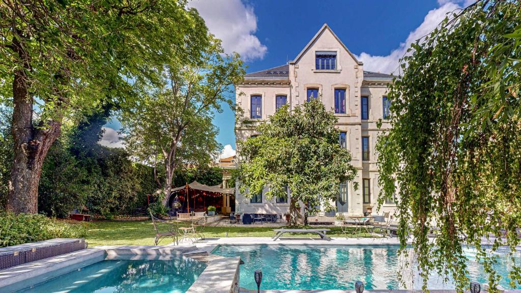 a large house with a swimming pool in front of it at Demeure Saint Louis Historic manor, City 700m, parking,A C,Clim,WIFI, heated pool, city view in Carcassonne