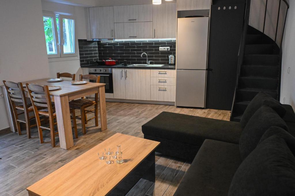 a living room and kitchen with a couch and a table at Mournia Apartment in Kroústas