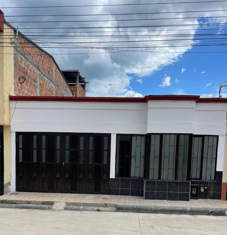 a white building with black windows on a street at La plata huila in La Plata