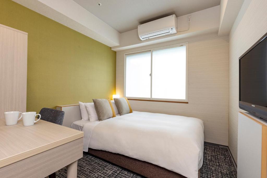 a hotel room with a bed and a tv at Tokyu Stay Tsukiji - Tokyo Ginza Area in Tokyo