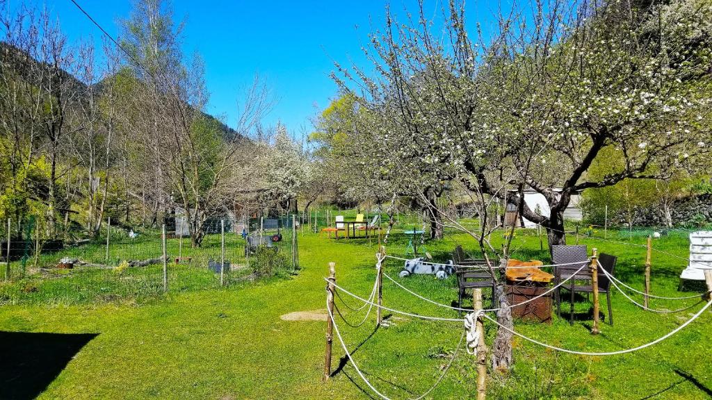 un parc avec une clôture et des arbres dans un champ dans l'établissement La Cérisole, à Saint-Étienne-de-Tinée