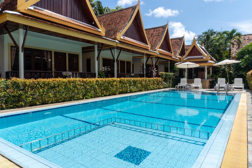 a swimming pool in front of a villa at Bangtao Village Resort - SHA in Bang Tao Beach
