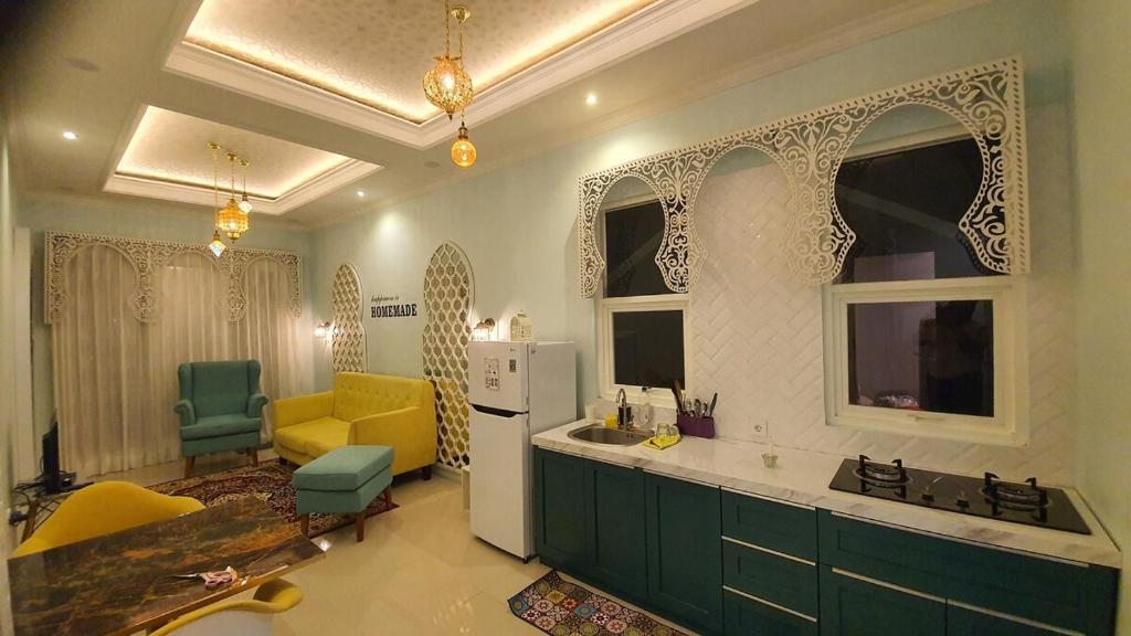 a kitchen with green cabinets and a yellow chair at Malang and Bromo Tour Riverside in Malang