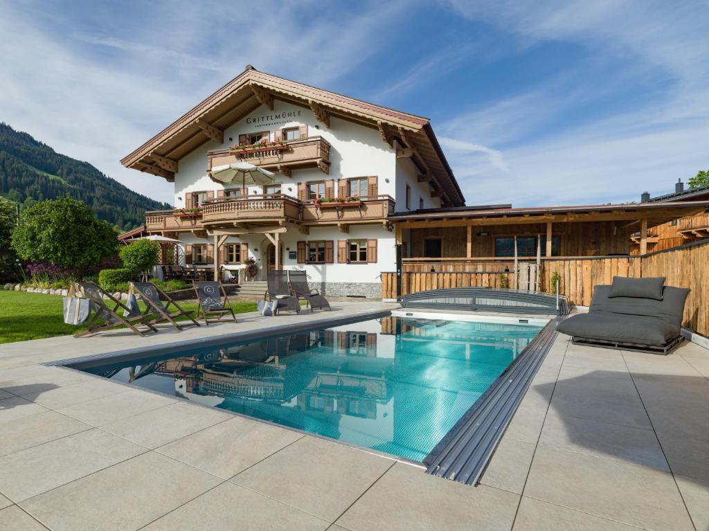 a house with a swimming pool in front of a house at Grittlmühle Chalet Ferienwohnungen in Brixen im Thale