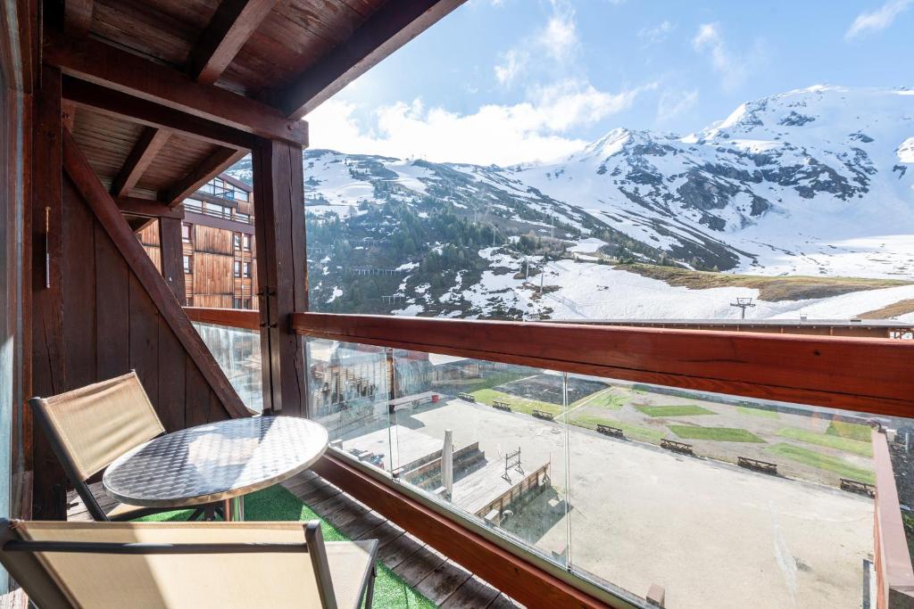 balcón con mesa y vistas a la montaña en Appartement Aiguille Rouge 420, en Bourg-Saint-Maurice