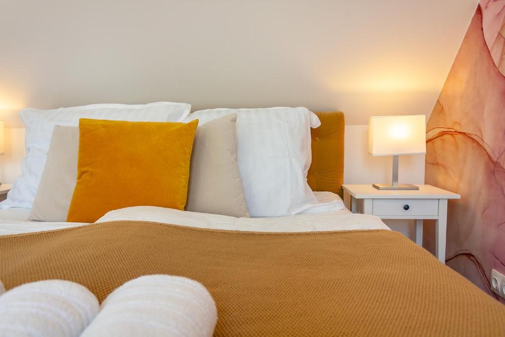 Schlafzimmer mit einem Bett mit weißen und gelben Kissen in der Unterkunft Monbuhim Comfort in Veszprém