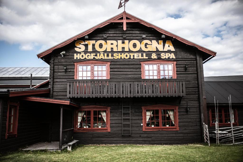 un bâtiment en bois avec un panneau sur son côté dans l'établissement Storhogna Högfjällshotell & Spa, à Storhågna