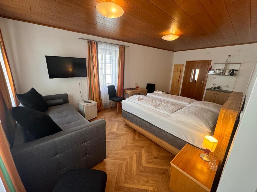 een slaapkamer met een groot bed en een bank bij Guesthouse Mozart - Apartment House in Salzburg