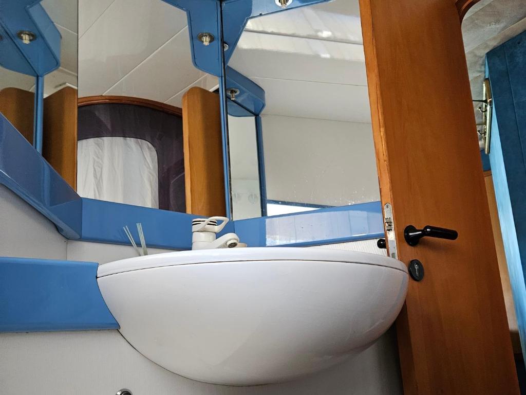 La salle de bains est pourvue d'un lavabo et d'un miroir. dans l'établissement Nuit insolite bateau à quai - Port Saint Louis du Rhône, à Port-Saint-Louis-du-Rhône