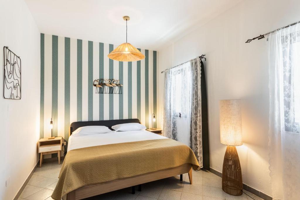 um quarto com uma cama e uma parede listrada em Alle Riserve Vendicari Country House em Noto