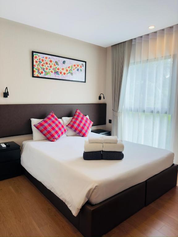 a bedroom with a large bed with red and white pillows at Title V in Rawai Beach
