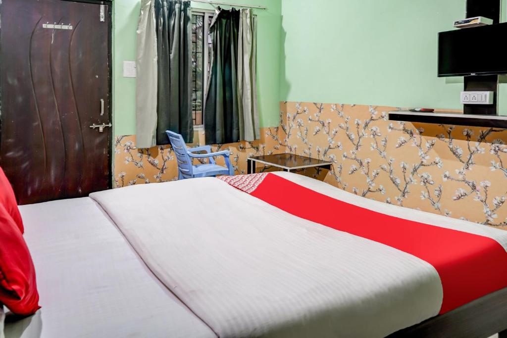 Schlafzimmer mit einem Bett mit einer roten und weißen Decke in der Unterkunft Hotel Welcome Sri Vip Road Raipur in Phundardih