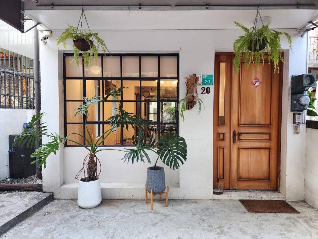 un bâtiment avec des plantes en pot devant une porte dans l'établissement Tree House, à Tainan
