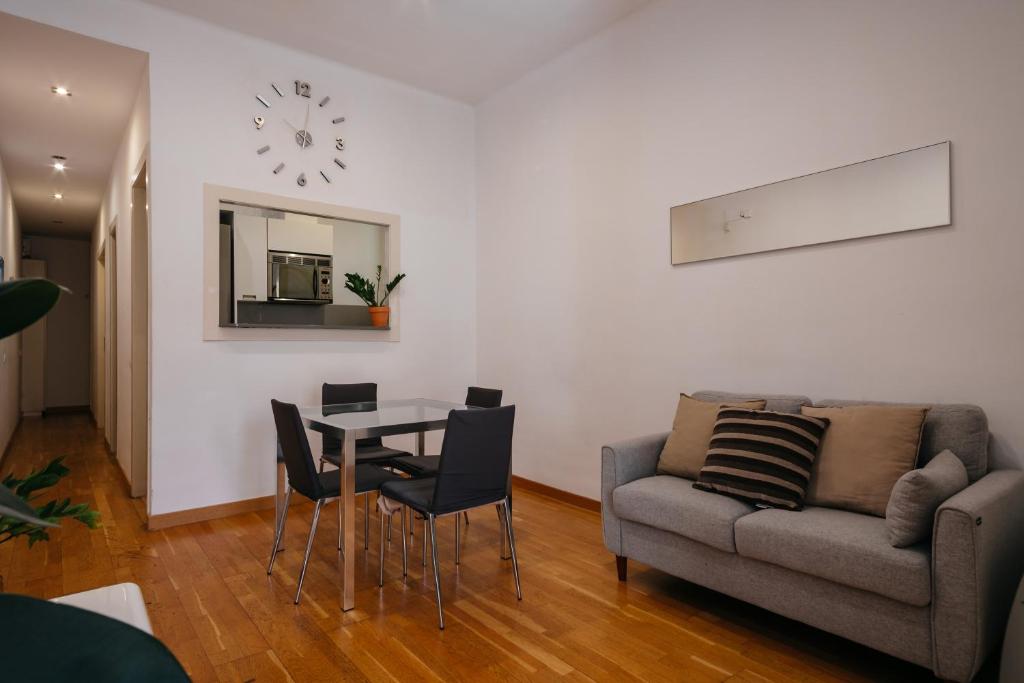 een woonkamer met een tafel en een bank bij Cute Apartment in Barcelona