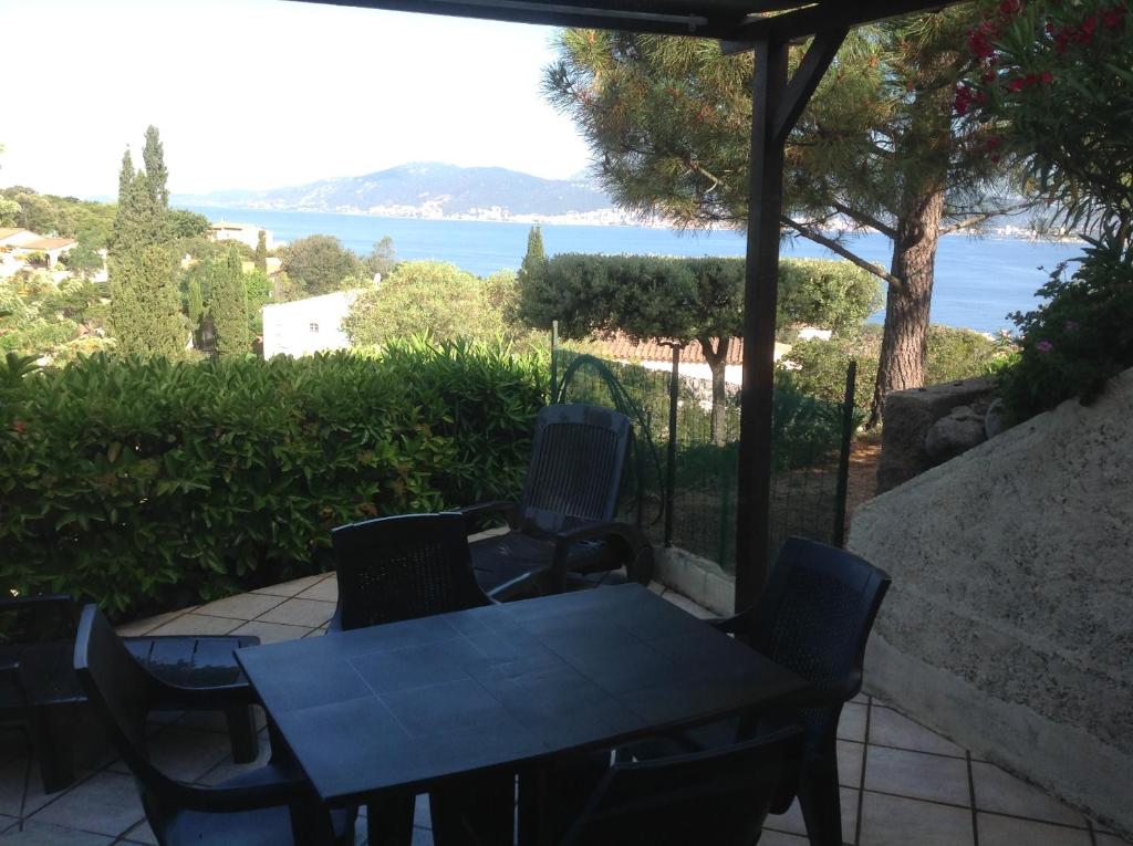 une table et des chaises sur une terrasse avec vue sur l'océan dans l'établissement Porticcio, à Porticcio