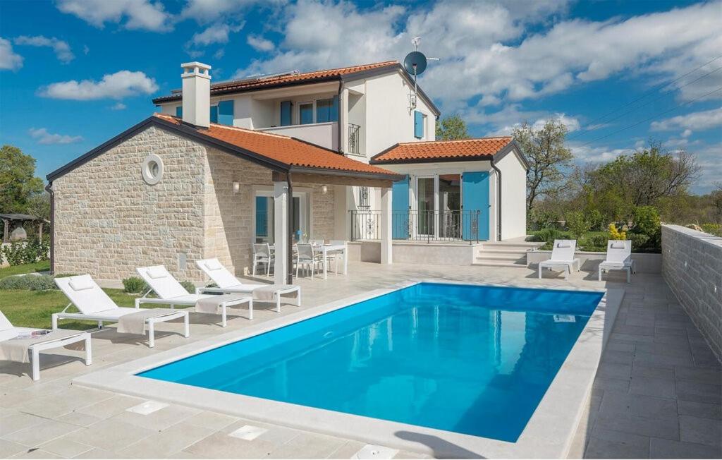 a villa with a swimming pool in front of a house at Villa Paulina by SeeAdria Agency in Buje
