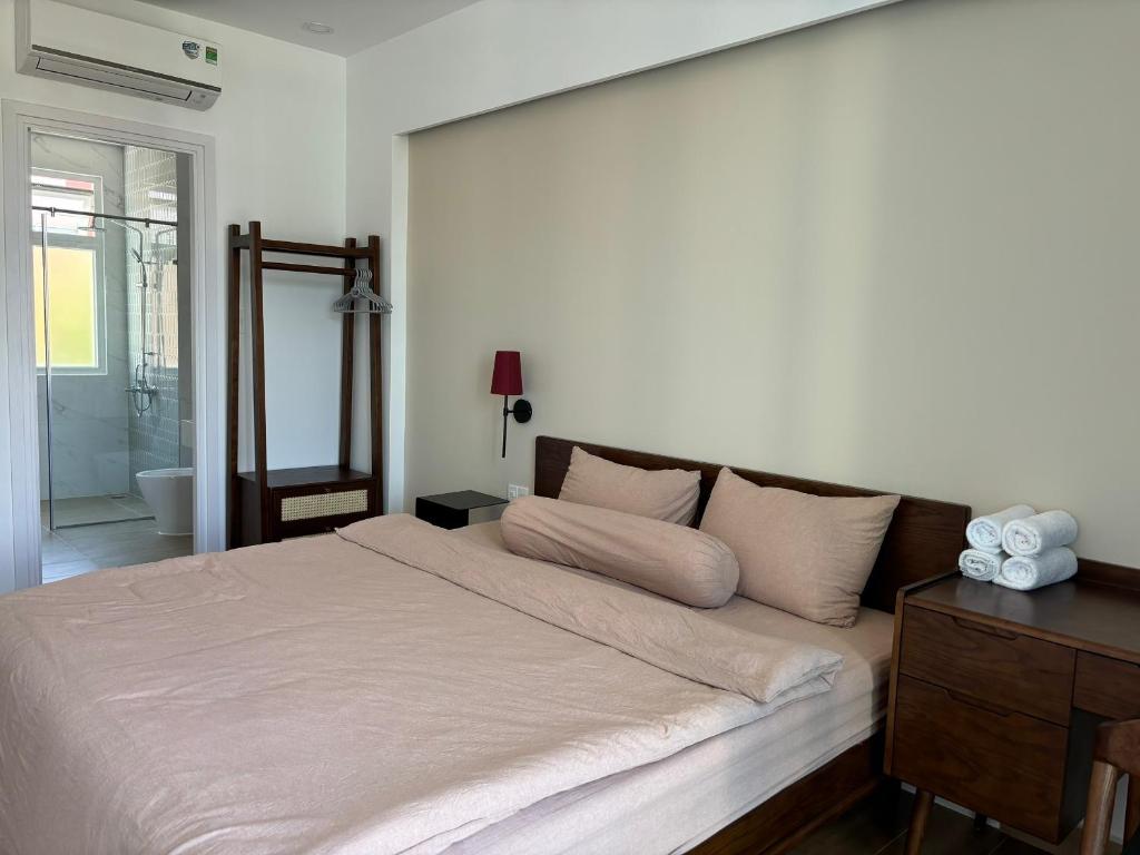 a bedroom with a large bed and a mirror at Chau's House Novaworld Phan Thiet in Bình Tú