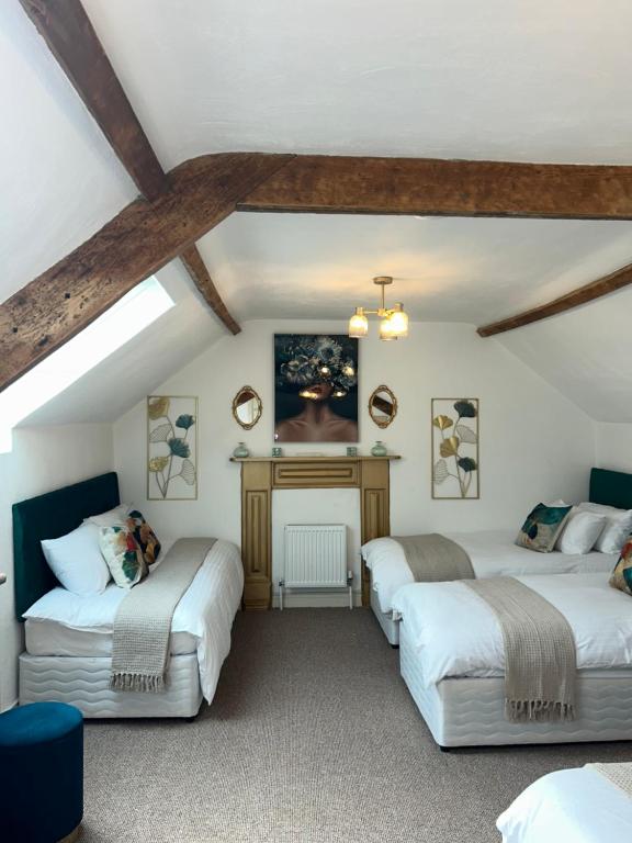 a attic room with two beds and a fireplace at Fitzgeralds - Ballybunion - Sleeps 34 in Ballybunion