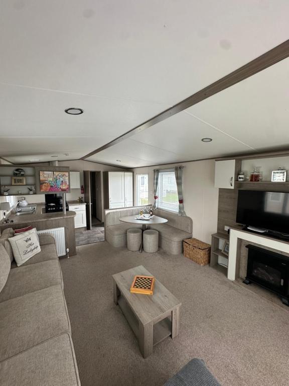 a large living room with a couch and a tv at New beach holiday park in Dymchurch