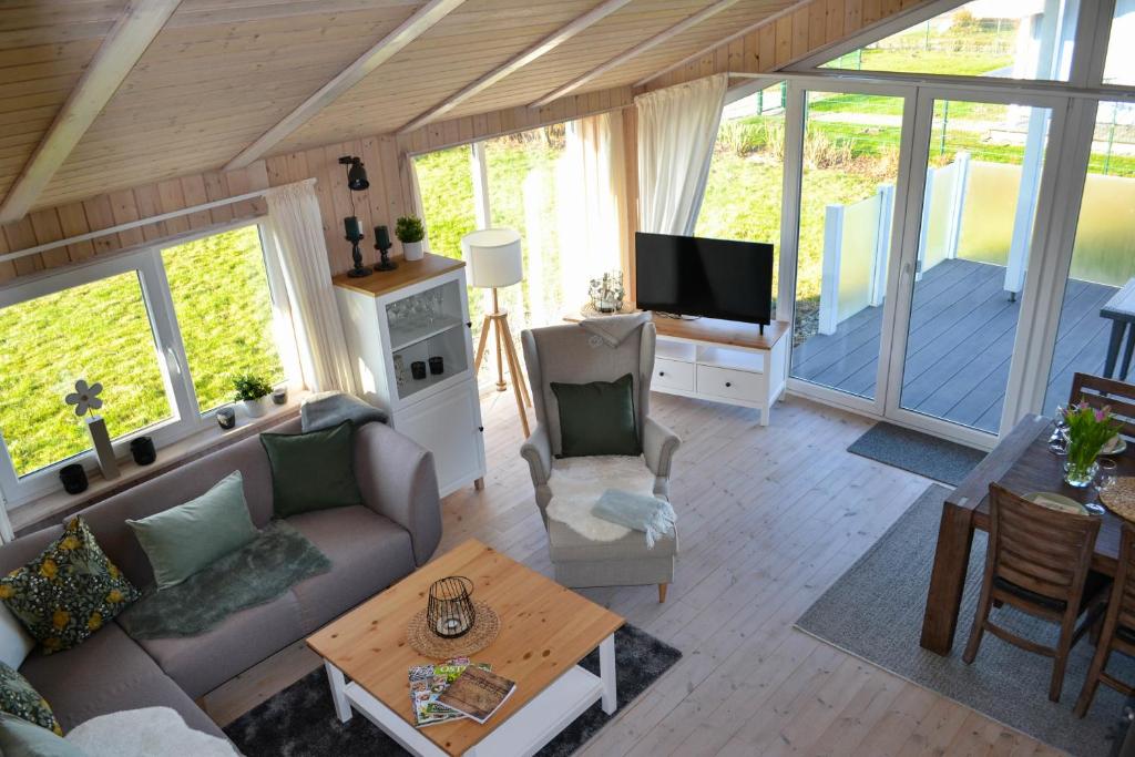 a living room with a couch and a tv at Ferienhaus "Deichglück" direkt an der Nordsee 2023 saniert in Wesselburenerkoog