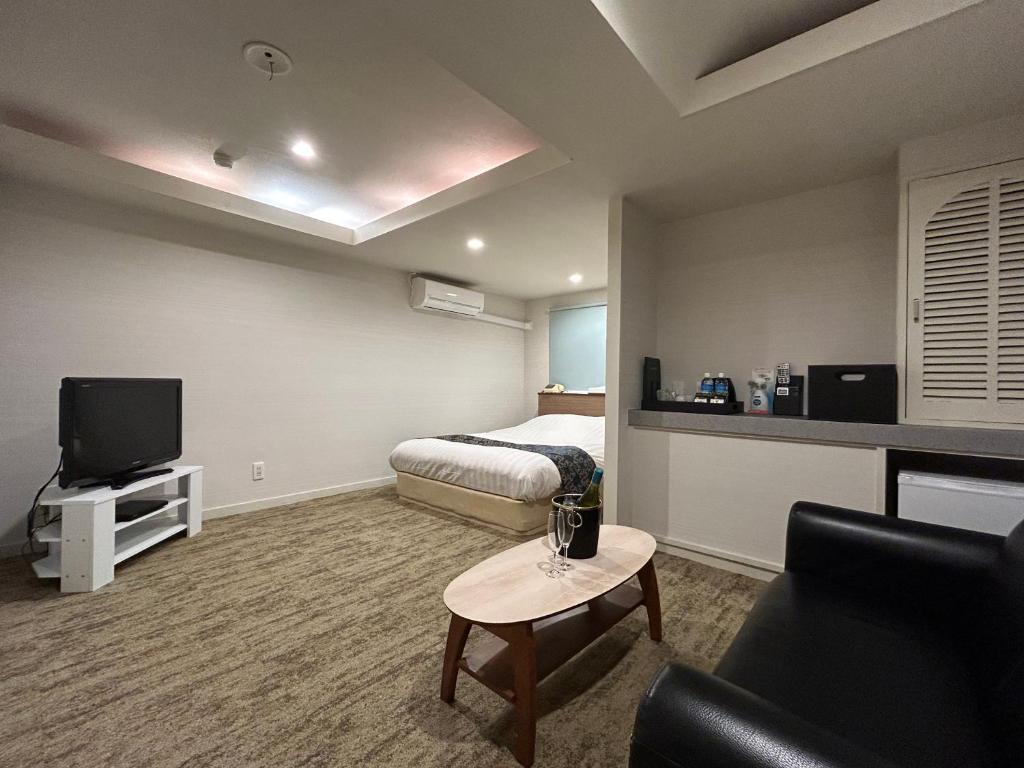 ein Hotelzimmer mit einem Bett und einem TV in der Unterkunft ホテルアイエス in Yokohama