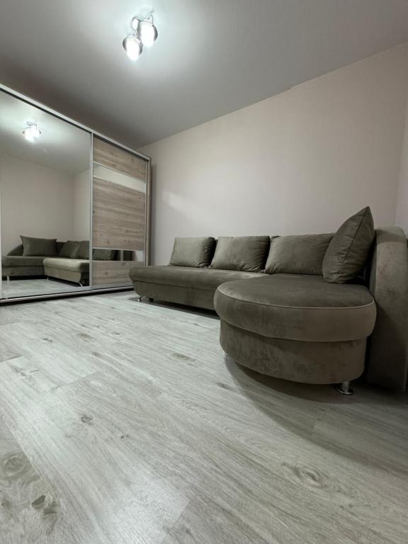 un soggiorno con divano e grande specchio di Candy Apartment a Chişinău