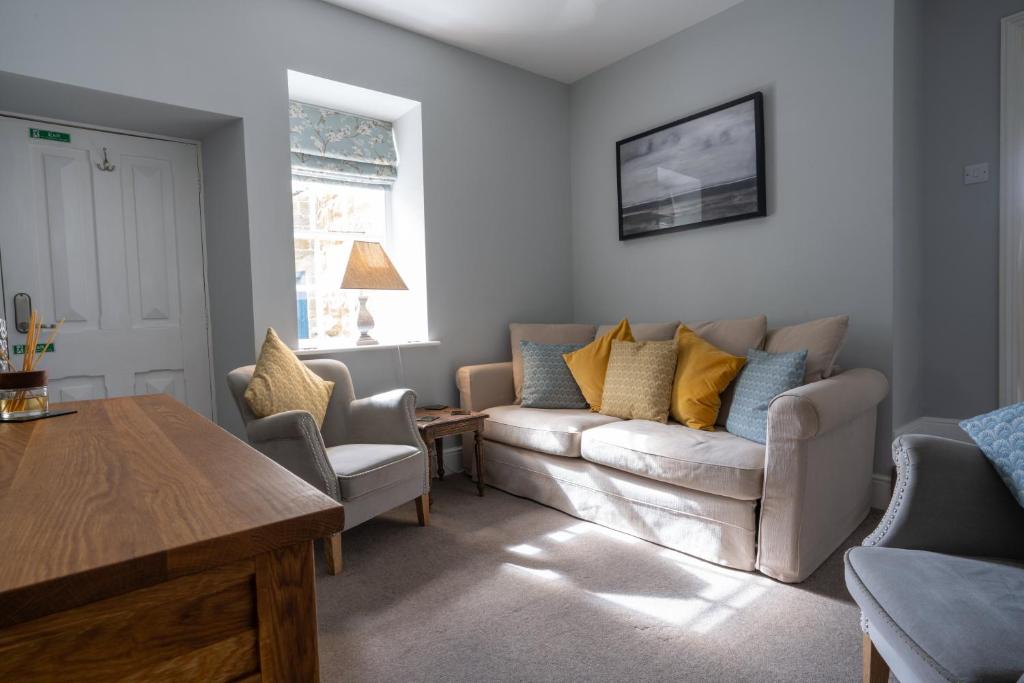 a living room with a couch and a table at Hassop Station Apartment on the Monsal Trail in Bakewell