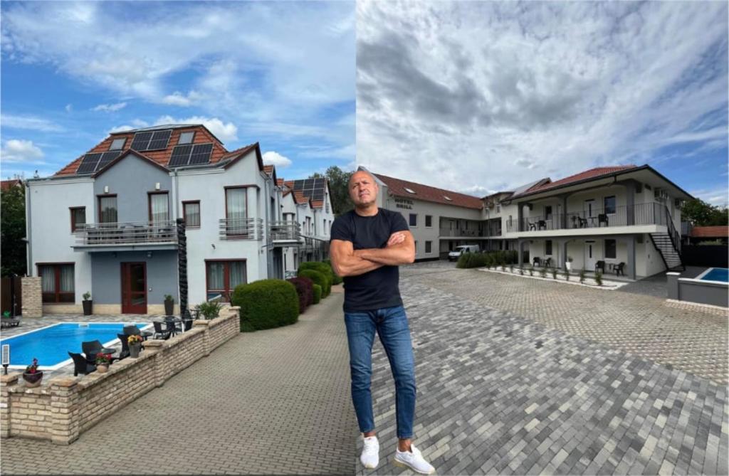 un hombre parado frente a una casa en Brill Hotel Békéscsaba, en Békéscsaba