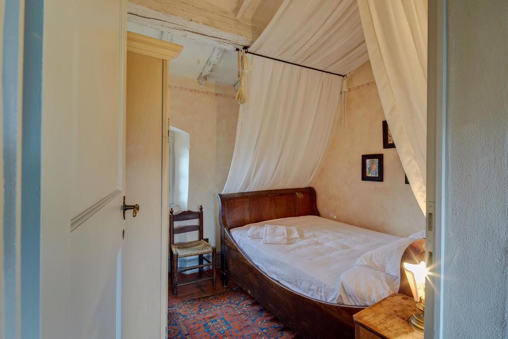 - une chambre avec un lit à baldaquin et une chaise dans l'établissement Wonderful Serena, à Coreglia Antelminelli
