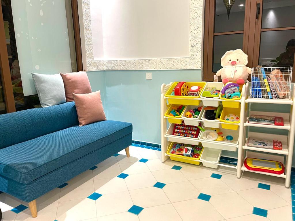 a living room with a couch and a shelf with toys at Mellon OASIS Phu Quoc in Phu Quoc