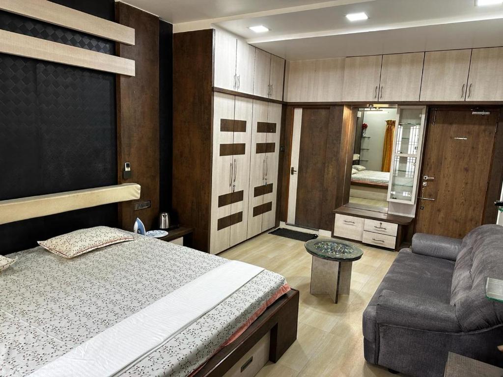 um quarto com uma cama, um sofá e uma cadeira em Temple View Home Stay em Tiruvannamalai