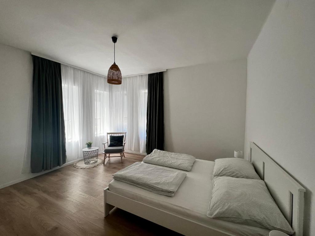 een slaapkamer met een bed en een stoel erin bij Best Apartman Boglár in Balatonboglár
