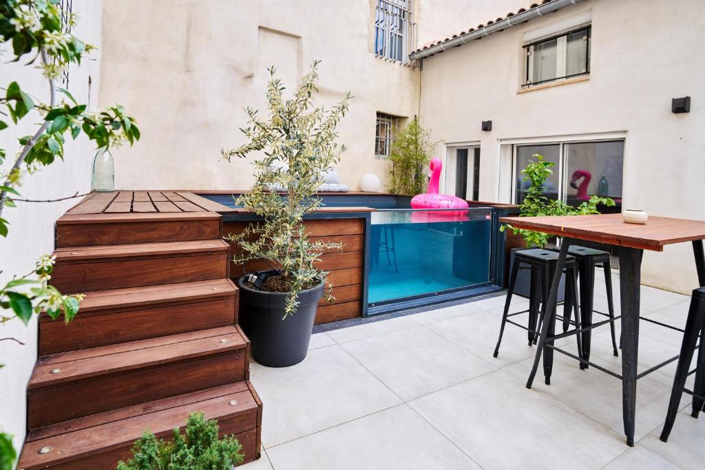 um pátio com uma mesa e uma piscina em Maison de ville moderne climatisée avec piscine em Morières-lès-Avignon