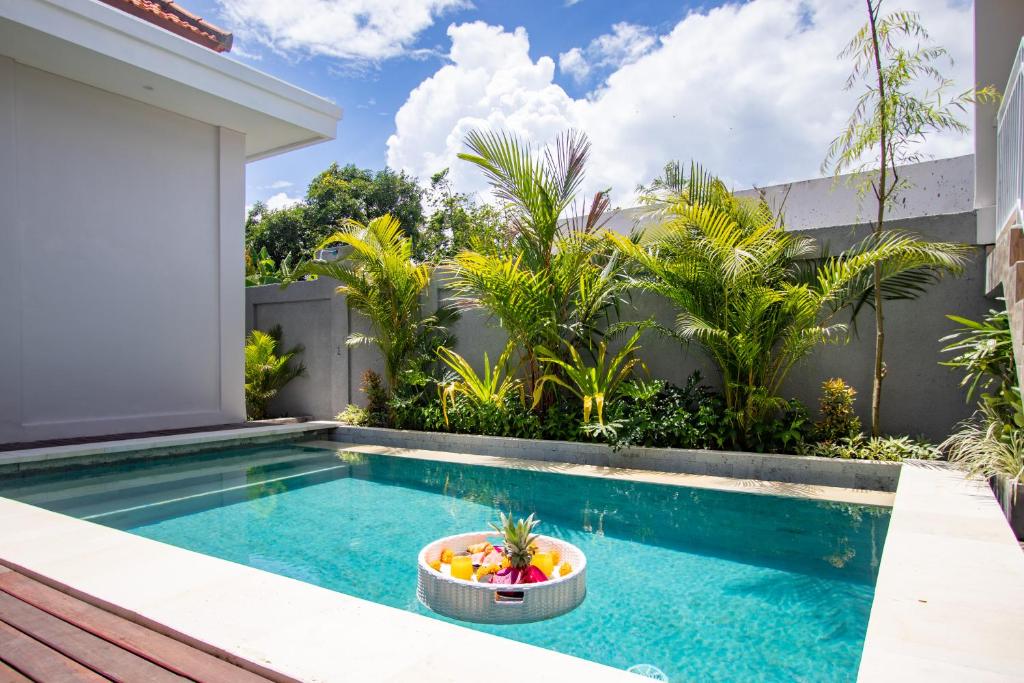 a pool with a bowl of fruit next to a house at CANGGU - 3BDR Villa with Private Pool and Rooftop and Ricefield View in Kerobokan