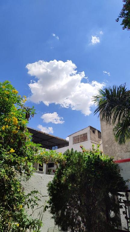 a building with clouds in the sky and trees at Hotel Heritage High in Udaipur