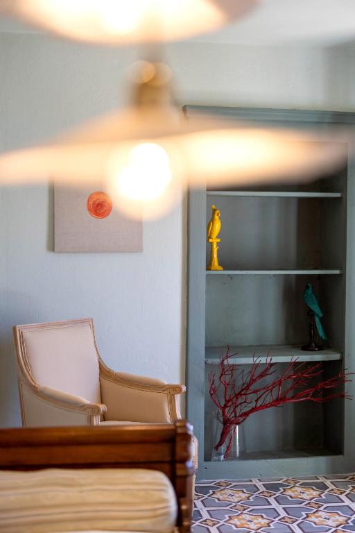 une pièce avec une chaise, une étagère et une lampe dans l'établissement L'appartement Macci, au coeur du port avec vue spectaculaire, à Calvi