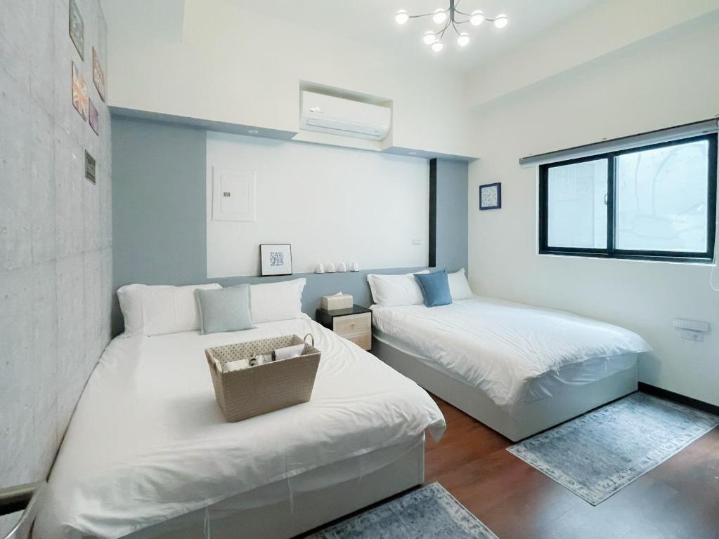 a bedroom with two beds and a window at 青和漫旅 Ching Ho Inn in Tainan