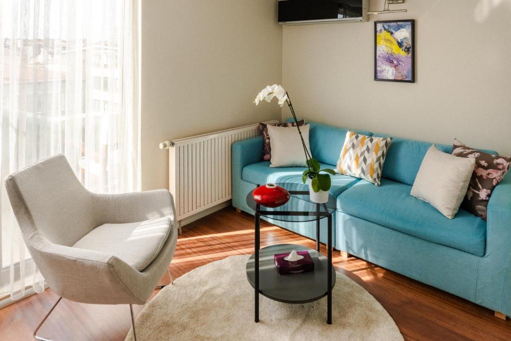 Cheya Deluxe Residence Nisantasi Istanbul City Center في إسطنبول: غرفة معيشة مع أريكة زرقاء وكرسي