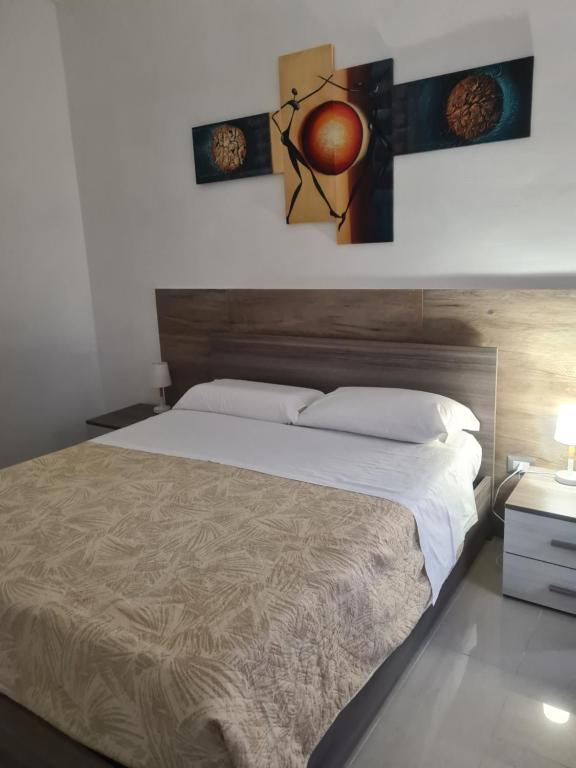 - une chambre avec un grand lit et deux photos sur le mur dans l'établissement Lido Venere Affittacamere, à Métaponte