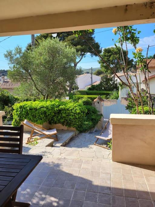 une terrasse avec une table, des bancs et des arbres dans l'établissement T2 neuf, RDJ dans villa sous les pins, port Carry, jardin terrasse indépendants, à Carry-le-Rouet