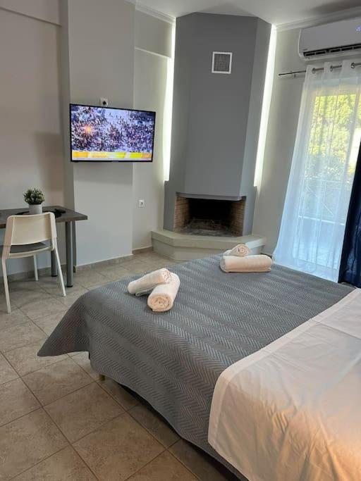 a bedroom with a bed with a fireplace and a tv at Margarita'S GetAway in Patra